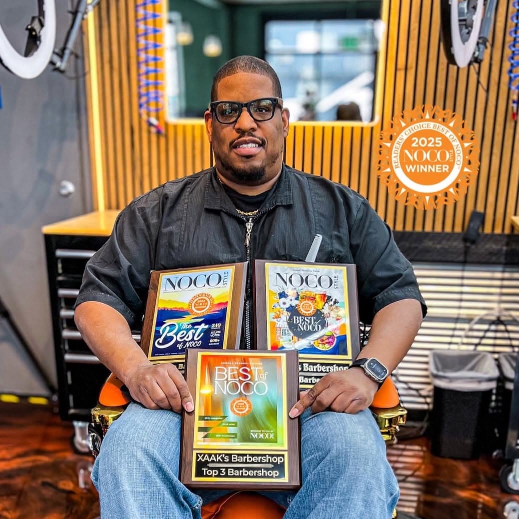 XAAK's owner holding Best of NoCo award plaques